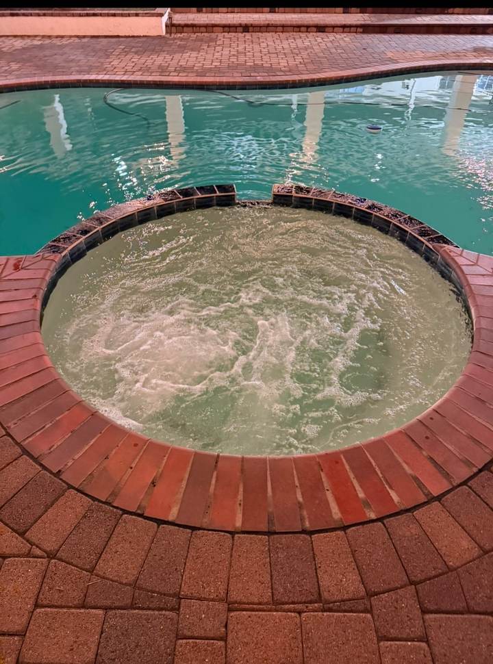 Raised spa with brick coping during a spa cleaning